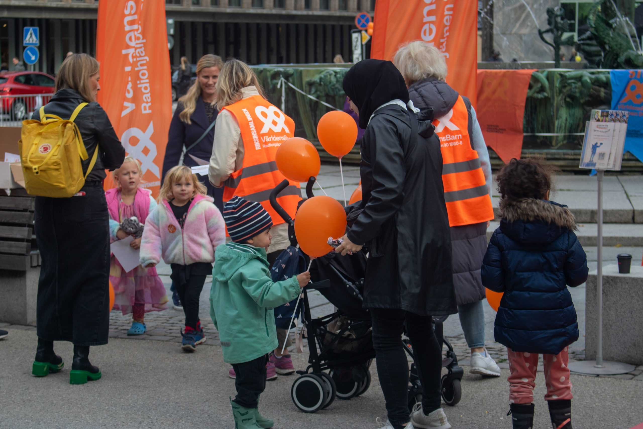 Familjer med orange ballonger.
